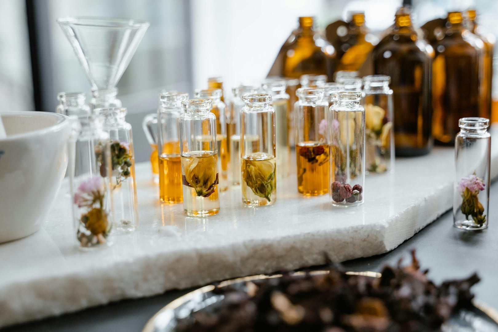 Close-up of various aromatic oils in glass bottles, showcasing their natural ingredients.